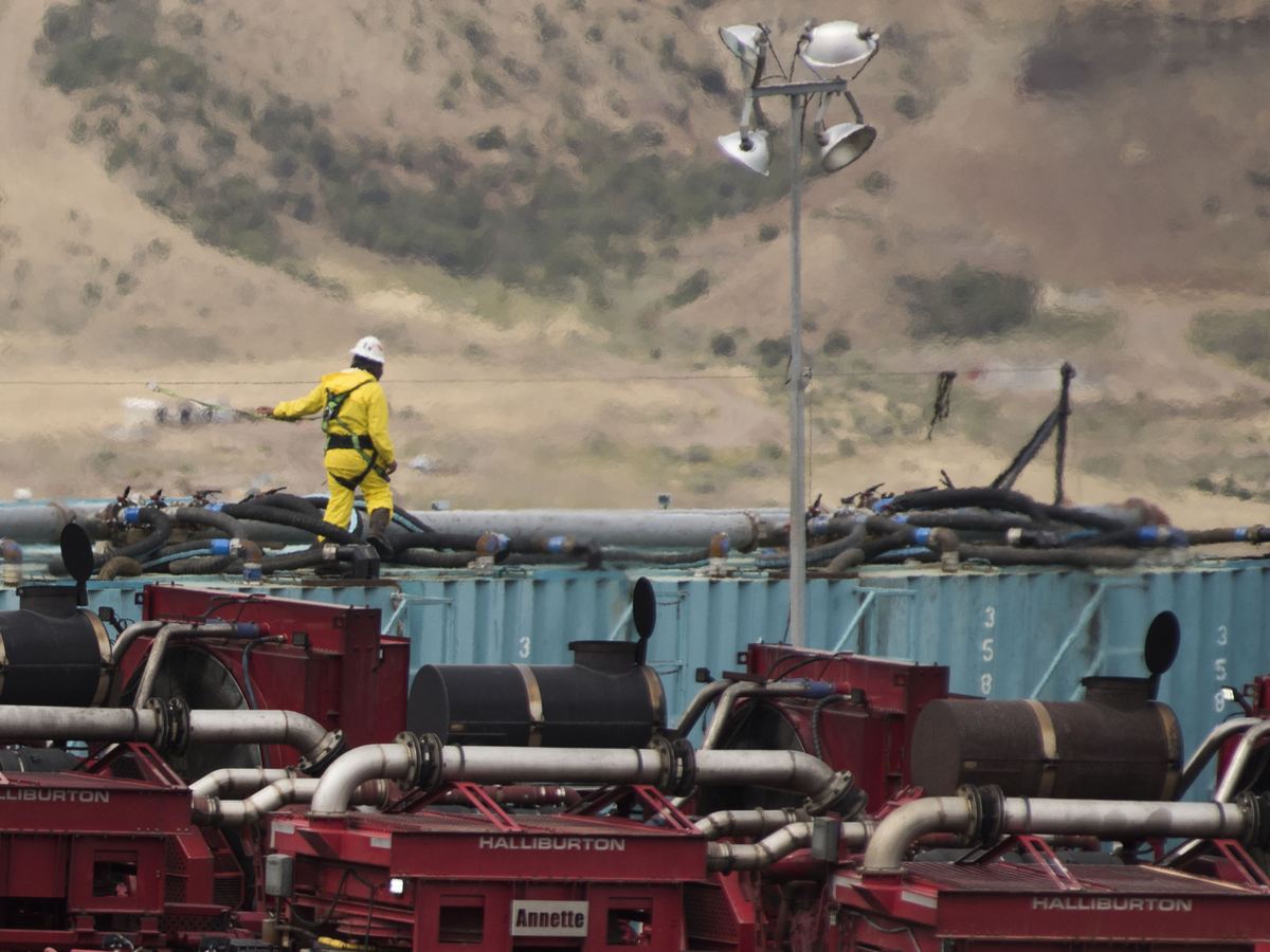 Fracking site worker standing on equipment in Colorado